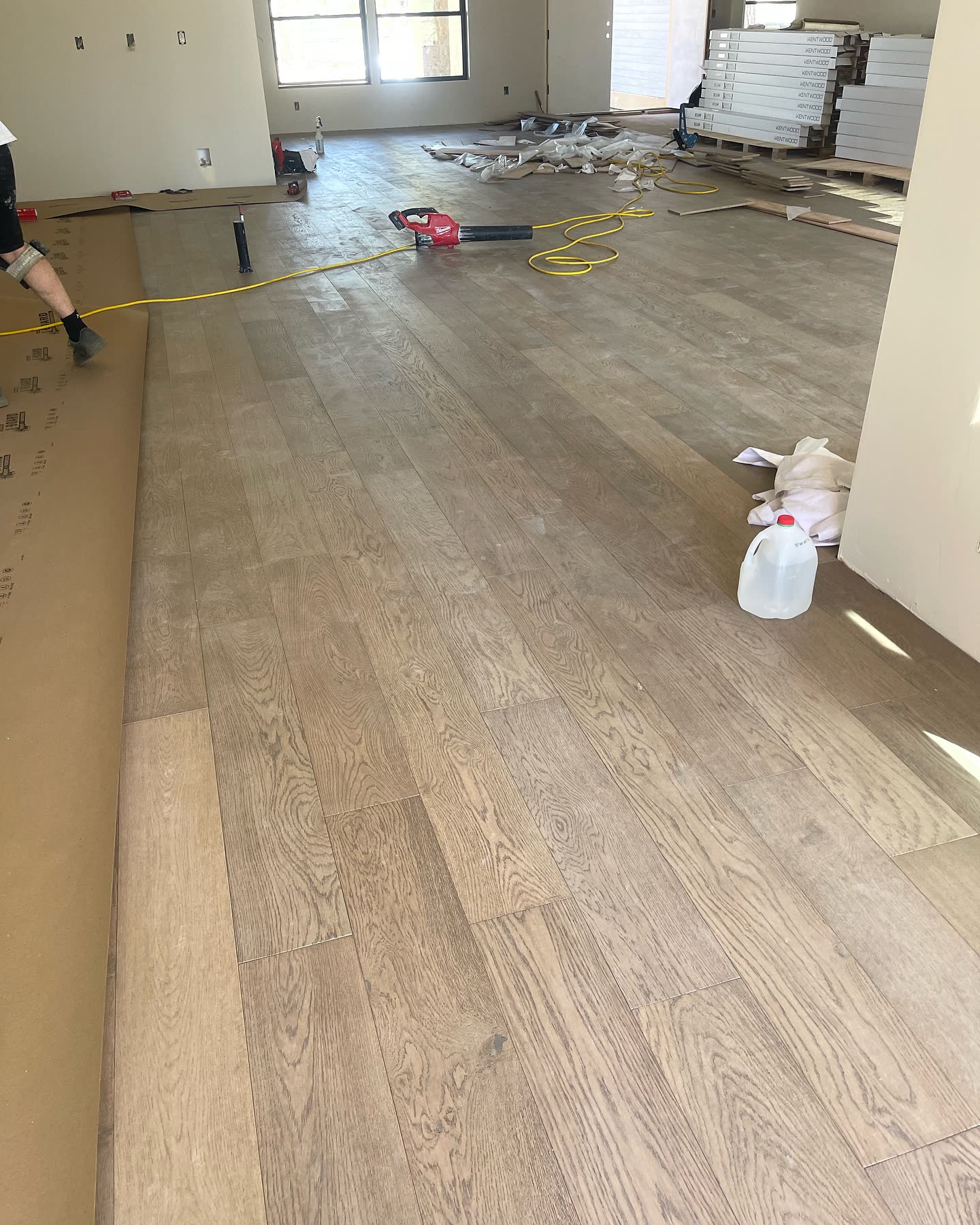 Grand Com crew installing wide-plank flooring on a custom home in the Portland–Vancouver area